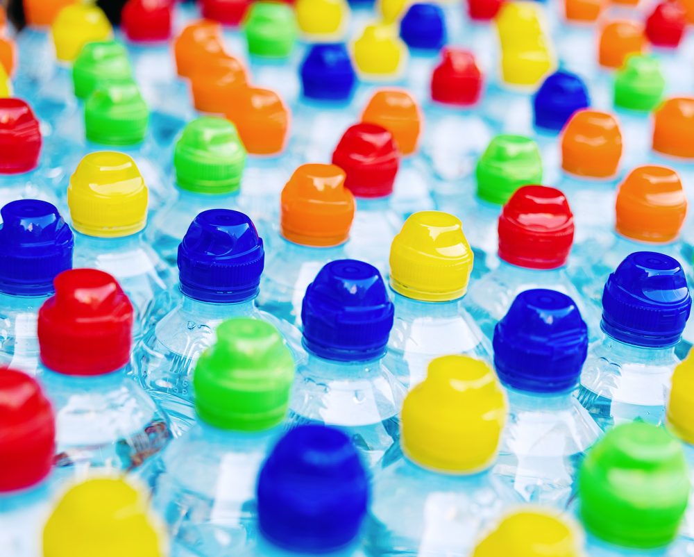 Colored stoppers of new plastic bottles, concept of pollution by recyclable plastics.